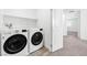 Convenient laundry room featuring a washer, dryer, and shelving for storage at 4125 Venus Falls Ave, North Las Vegas, NV 89084