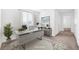A bright and modern office space with a large desk, stylish rug, and view of the hallway at 4125 Venus Falls Ave, North Las Vegas, NV 89084