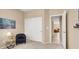 Neutral carpeted bedroom featuring a closet, chair, and view to the hallway at 4443 Verdiccio Ave, Las Vegas, NV 89141