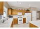 The kitchen is equipped with bright white appliances, ample wooden cabinet space, and natural light at 4443 Verdiccio Ave, Las Vegas, NV 89141