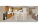 Bright kitchen with an island, white appliances, and breakfast bar seating connecting to the living area at 4443 Verdiccio Ave, Las Vegas, NV 89141
