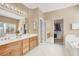 Well-lit bathroom featuring double vanity, separate tub, walk in closet and shower at 4443 Verdiccio Ave, Las Vegas, NV 89141