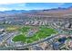 Aerial view showcases a sprawling community, highlighting the green space and mountain backdrop at 502 Sonoma Range St, Las Vegas, NV 89138
