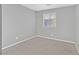 This is a simple bedroom with gray walls and carpet and a window with blinds at 502 Sonoma Range St, Las Vegas, NV 89138