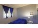 Comfortable bedroom featuring a cozy bed, bright window with dark curtains, and neutral-toned walls at 5517 Rose Thicket St, Las Vegas, NV 89130