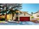 Charming two-story home featuring a red two-car garage door and a well-maintained front yard at 5517 Rose Thicket St, Las Vegas, NV 89130