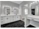 Bright bathroom with double vanity, white cabinets, marble countertops, and stylish black and white flooring at 5601 Mary Lou St, Pahrump, NV 89061