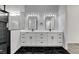Bright bathroom featuring a double vanity with white cabinets, marble countertops, and a walk-in shower at 5601 Mary Lou St, Pahrump, NV 89061