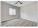 Bright bedroom with wood-look floors, neutral walls, and a modern ceiling fan at 5601 Mary Lou St, Pahrump, NV 89061