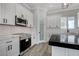 Modern kitchen with white cabinets, stainless steel appliances, and a stylish black countertop island at 5601 Mary Lou St, Pahrump, NV 89061