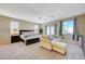 Spacious main bedroom with sitting area, ceiling fan, and carpet flooring and natural light at 5824 Farmhouse Ct, Las Vegas, NV 89141