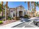 Exterior of a clubhouse showcases well-manicured landscaping, palm trees, and convenient parking at 5855 Valley Dr # 2020, North Las Vegas, NV 89031