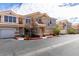 Exterior of townhomes features multiple garages and stories, red-tile roofs, and landscape maintenance at 5855 Valley Dr # 2020, North Las Vegas, NV 89031
