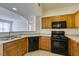 Kitchen featuring oak cabinets, granite countertops, and black appliances at 5855 Valley Dr # 2020, North Las Vegas, NV 89031