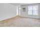 Spacious living room with large windows and neutral carpet, ready for personal touches at 5855 Valley Dr # 2020, North Las Vegas, NV 89031