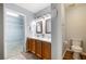 Bright bathroom featuring dual sinks, wood cabinets, and a separate toilet room at 6120 Crystal Cascade St, Las Vegas, NV 89130