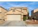 Two-story home with a tan exterior, a two-car garage, and desert landscaping at 6120 Crystal Cascade St, Las Vegas, NV 89130