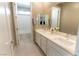 Bright bathroom featuring double sink vanity, large mirror, and a view of the bathtub/shower area at 6197 Jewel Vista St, Las Vegas, NV 89135
