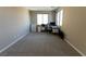 Bright bedroom with neutral decor featuring a desk setup, carpet, and a large window for natural light at 6197 Jewel Vista St, Las Vegas, NV 89135