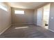 Neutral bedroom featuring gray carpet, natural light from horizontal windows, and entry to the bathroom at 6197 Jewel Vista St, Las Vegas, NV 89135
