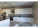 Bright kitchen features stainless steel appliances, mosaic backsplash, and an island with bar seating, ready for entertaining at 6197 Jewel Vista St, Las Vegas, NV 89135