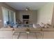 Cozy living room with neutral decor, large sectional sofa, and sliding glass door to the patio at 6197 Jewel Vista St, Las Vegas, NV 89135