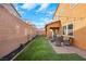 Serene backyard with a covered patio, artificial grass, and a brick wall for added privacy and outdoor enjoyment at 632 Loyalty Ct, Henderson, NV 89011