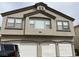 A two-story townhouse featuring a three-car garage, a neutral stucco facade, and neatly trimmed windows at 6462 Saddle Up Ave # 103, Henderson, NV 89011