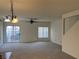 Spacious living room with carpet, ceiling fan, and sliding glass doors leading to the backyard at 6462 Saddle Up Ave # 103, Henderson, NV 89011