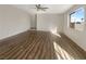 Bright living room with hardwood floors, ceiling fan, and large window letting in natural light at 6479 Gunderson Blvd, Las Vegas, NV 89103