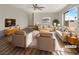 Bright living room with hardwood floors, neutral paint, large windows, and comfortable seating arrangement. (Virtually Staged) at 6479 Gunderson Blvd, Las Vegas, NV 89103