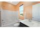 This bathroom features a shower-tub combination, a dark vanity and bright lighting at 6602 Windy Palm St, North Las Vegas, NV 89086