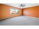 This bright bedroom features large windows, neutral carpet, and a ceiling fan at 6602 Windy Palm St, North Las Vegas, NV 89086