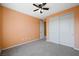 This cozy bedroom features neutral carpet, modern ceiling fan and spacious closet at 6602 Windy Palm St, North Las Vegas, NV 89086