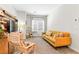 Well-lit living room featuring a yellow couch, modern chair, and a cat tree for feline friends at 7350 N Decatur Blvd # 5, Las Vegas, NV 89131