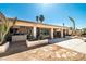 Expansive backyard featuring a covered patio, outdoor kitchen, lush greenery, and desert landscaping at 800 Kenny Way, Las Vegas, NV 89107