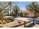 Home exterior with mature desert landscaping and a long driveway leading to an attached garage at 800 Kenny Way, Las Vegas, NV 89107