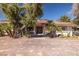 Home exterior featuring desert landscaping, large mature trees, and a brick-paved driveway at 800 Kenny Way, Las Vegas, NV 89107