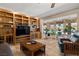 Bright living room with wood built-ins, tile floor, and several windows with a view of the backyard at 800 Kenny Way, Las Vegas, NV 89107