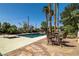 Outdoor swimming pool with a baja shelf, lounge seating, mature landscaping, and desert flora at 800 Kenny Way, Las Vegas, NV 89107