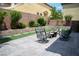 Landscaped backyard with stone retaining wall, patio, faux grass, and comfortable seating arrangement at 8122 Retriever Ave, Las Vegas, NV 89147
