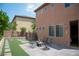 Private backyard featuring brick patio, faux grass inserts, and comfortable seating area at 8122 Retriever Ave, Las Vegas, NV 89147