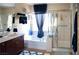 This bathroom has a white bathtub, glass-enclosed shower, double vanity, and brown cabinets at 8122 Retriever Ave, Las Vegas, NV 89147