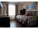 A neatly decorated bedroom with a large bed, a modern dresser, and an ocean-themed painting at 8122 Retriever Ave, Las Vegas, NV 89147