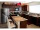 Cozy kitchen with dark wood cabinets, granite countertops, stainless steel appliances, and a center island at 8122 Retriever Ave, Las Vegas, NV 89147