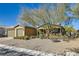 Tan single-story home featuring a well-manicured front yard and desert landscaping at 8514 Garnet Lake Ave, Las Vegas, NV 89113