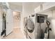 Well-organized laundry room with modern washer, dryer, storage shelves, and stylish wood-look tile flooring at 8514 Garnet Lake Ave, Las Vegas, NV 89113