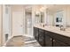 Bright bathroom featuring dual sinks, herringbone tile, and a glass door shower at 8514 Garnet Lake Ave, Las Vegas, NV 89113