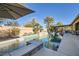 Stunning backyard pool features in-pool loungers, a spa, and lush tropical landscaping for outdoor enjoyment at 8514 Garnet Lake Ave, Las Vegas, NV 89113