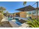Outdoor pool area boasts a relaxing spa, lounge chairs, covered dining space, and lush landscaping at 8514 Garnet Lake Ave, Las Vegas, NV 89113